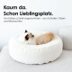Zwei Katzen zusammengerollt in einem weißen runden Katzenbett auf einem Sofa; sichtbarer Text: "Kaum da. Schon Lieblingsplatz."