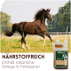 Löffel mit goldenem Schwarzkümmelöl und Flasche Supravit Schwarzkümmelöl, 100 % reines kaltgepresstes Öl, auf Holzoberfläche.