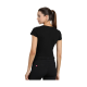 Eine Frau ist von hinten zu sehen, trägt ein enges schwarzes T-Shirt und schwarze Hosen mit einem strukturierten Gürtel.