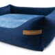 Marineblaue Haustierbett mit einem weichen blauen Innenraum und einem Lederschild, auf dem "RexProduct.com" steht.