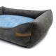 Graues Haustierbett mit einem weichen blauen Kissen, ausgestattet mit einem Lederetikett, auf dem "RexProduct.com" steht.