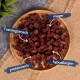Eine Holzschüssel gefüllt mit kleinen, würfelförmigen Hundeleckerlis, gekennzeichnet als 'Trainingssnack', 'fettarm', 'hochprotein' und 'hypoallergen'.