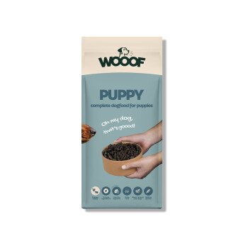WOOOF-Welpenfuttertüte mit Aufschrift 'PUPPY – vollständiges Hundefutter für Welpen' und 'Oh my dog, that's goood!', Hände halten Schüssel mit Kroketten, Hundeschnauze