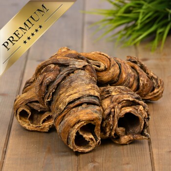 Premium-Haustier-Kauartikel, gedreht und strukturiert, auf einer Holzoberfläche mit grünem Gras im Hintergrund präsentiert.