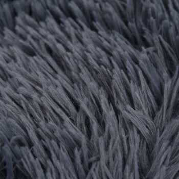 Nahaufnahme von weichem, grauem Haustierbettmaterial mit langen, flauschigen Fasern, ideal für den Komfort und die Wärme von Haustieren.