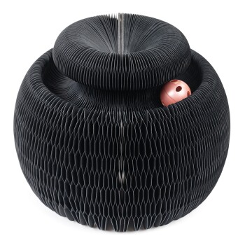 Schwarzes Honigwaben-Stil Haustier-Spielzeug mit runder Form und einem kleinen rosa Ball, der oben herauslugt.