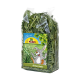 Un sac en plastique transparent rempli de foin d'avoine vert, avec une étiquette colorée avec un lapin en dessin animé et le texte "JR FARM Grüner Hafer."