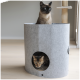 Eine Siamkatze sitzt auf einem grauen Filz-Katzenbaum, während eine Bengal-Katze aus einer runden Öffnung an der Basis herausblickt.