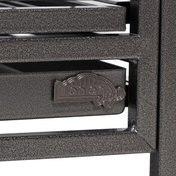 Nahaufnahme eines dunklen, strukturierten Haustierkäfigs mit sichtbarem "Montana Cages"-Logo auf der vorderen Schublade.