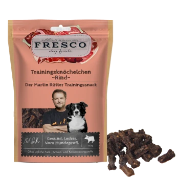 FRESCO Hundefutter-Beutel "Trainingsknöchelchen - Rind", Martin Rütter Trainingssnack, 150 g, mit Hundeabbildung und einem Haufen Rindfleischleckerlis.