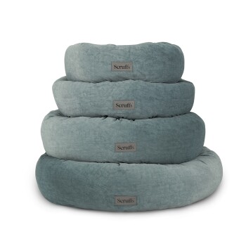 Stapel von vier weichen, runden Hundebetten in einem gedämpften Teal-Farbton, jedes mit einem Scruffs-Logo gekennzeichnet.