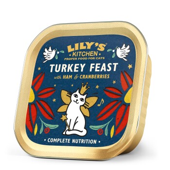 L'emballage de nourriture pour chat Lily's Kitchen Turkey Feast montre un chat blanc couronné avec des fleurs, étiqueté "Turkey Feast with Ham & Cranberries."