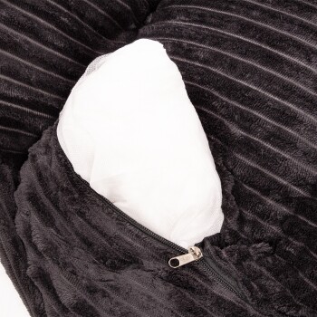 Nahaufnahme eines schwarzen Haustierbettes mit einem Reißverschluss, der ein weißes Innenkissen zeigt, das aus weichem, plüschigem Stoff besteht.