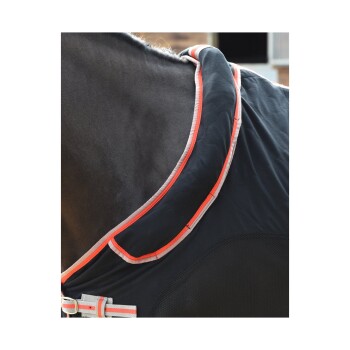 Nahaufnahme einer Pferde-Decke aus schwarzem Stoff mit rotem und grauem Besatz, die den Kragen und die Verschlussdetails zeigt.