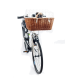 Ein weißes Fahrrad mit einem braunen Korb aus Weide vorne, in dem ein Mops-Hund hervorschaut, der hinter einem Metallkäfig sitzt.