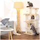 Drei flauschige Katzen spielen auf einem beigen Katzenbaum in einem gemütlichen Wohnzimmer, das eine stilvolle Lampe und ein graues Sofa mit dekorativen Kissen zeigt.