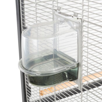 Ein klarer Kunststoff-Wasserspender, der an einem Metallkäfig befestigt ist, mit einer gebogenen Oberseite und einem unteren Reservoir für einfachen Zugang.