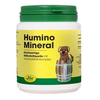 Weißer Behälter mit 'Humino Mineral' Haustierergänzungsmittel mit grünem Deckel, mit einem Cartoonhund und Nährwertinformationen auf Deutsch.