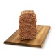 Ein rechteckiger Block Haustierfutter auf einem Holzschneidebrett, der eine strukturierte, fleischige Oberfläche zeigt.