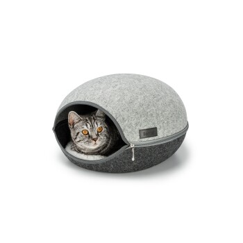 Ein gemütliches, rundes Katzenbett mit einem grauen Filzaußen und einem dunkelgrauen Boden, mit einer Katze mit auffälligen orangefarbenen Augen, die herausblickt.
