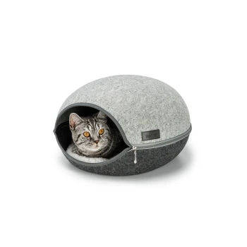 Ein gemütliches, rundes Katzenbett mit einem grauen Filzaußen und einem dunkelgrauen Boden, mit einer Katze mit auffälligen orangefarbenen Augen, die herausblickt.