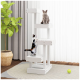 Zwei Katzen spielen auf einem modernen weißen Katzenbaum mit mehreren Ebenen, in einem hellen Raum mit einer grünen Pflanze und einem Tennisball auf dem Boden.