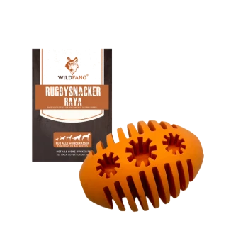 Orangenes rugbyförmiges Hundespielzeug aus Naturkautschuk, mit einer Verpackung, die "RUGBYSNACKER RAYA" von Wildfang beschriftet ist.