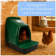 Grüner wandmontierter Hühner-Nistkasten in einem Strohstall, zwei Hühner; sichtbarer Text: 'Schrägdach verhindert Draufsitzen und Verschmutzen'