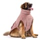 Ein großer Hund, der einen weichen, rosa handtuchartigen Bademantel trägt, sitzt aufrecht und sieht glücklich aus mit herausgestreckter Zunge.