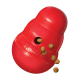 Red KONG Classic treat-dispensing dog toy with kibble spilling from hole; embossed "KONG" visible.