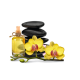 Eine Flasche gelbes Öl mit einem Korken, umgeben von schwarzen Steinen und lebhaften gelben Orchideen, die eine beruhigende, spa-ähnliche Szene schaffen.