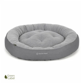 Graues rundes Haustierbett mit gepolstertem Design, gekennzeichnet mit "Doctor Bark," mit einem weichen Stoff und einem "Green Label"-Logo.
