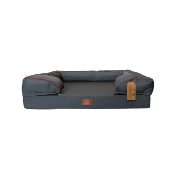 Gray rectangular dog bed with raised bolsters, red piping and hex pattern, leather tag reading "Beddies".