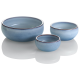 Drei keramische Haustierschalen in verschiedenen Größen, mit einer glatten blauen Oberfläche und einem kontrastierenden Rand, die auf einer weißen Oberfläche reflektieren.