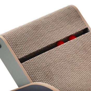 Nahaufnahme eines Katzenkratzbaums mit einer strukturierten beigen Oberfläche und zwei roten Bällen, die in einer Rille oben sichtbar sind.