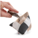 Eine Hand gießt getrocknete Kräuter aus einem klaren Röhrchen in ein dreieckiges, kariertes Katzenspielzeug mit einer kleinen Öffnung.