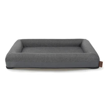 Graues rechteckiges Haustierbett mit einem gepolsterten Innenraum und erhöhten Rändern, mit einem eleganten Design und einem braunen Etikett an der Seite.