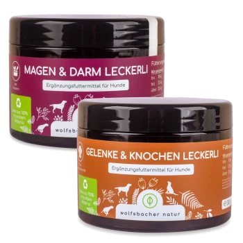 Zwei Gläser mit Hundesupplementen von Wolfsbacher Natur: lila "Magen & Darm Leckerli" und orange "Gelenke & Knochen Leckerli."