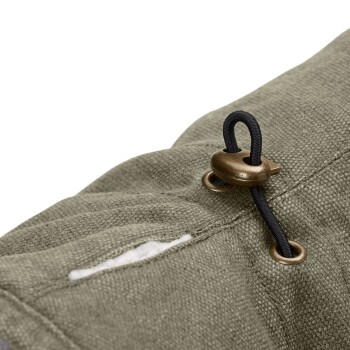 Nahaufnahme eines grünen Haustierzubehörs mit einem bronzenen Toggle und schwarzem Kordelzug, das seinen strukturierten Stoff zeigt.