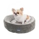 Ein kleiner Hund sitzt in einem runden, plüschigen grauen Haustierbett mit weißem Innenraum, das ein blaues Logo mit der Aufschrift "WALLACE & JONES" zeigt.