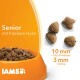 Senioren-Haustierfutter mit frischem Huhn in einer orangefarbenen Schüssel, mit Kibble-Stücken daneben, die einen Durchmesser von 10 mm und eine Dicke von 3 mm haben.