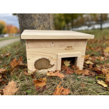 Holz-Igelhaus mit einem ausgeschnittenen Igel-Design, beschriftet mit "My Little Farm", umgeben von Herbstblättern.