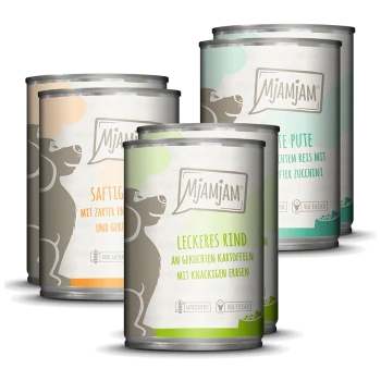 Vier Dosen Mjamjam Hundefutter mit verschiedenen Geschmacksrichtungen: 'Saftiges Rind', 'Leckeres Rind', 'Zarte Pute' und 'Hühnchen.'