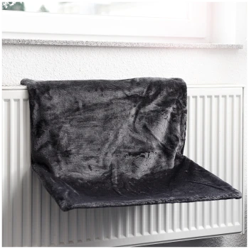Ein weiches, dunkelgraues Haustierbett, das über einem Heizkörper hängt, entworfen für Haustiere zum Entspannen und Warmhalten.