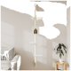 Ein moderner weißer Katzenbaum mit drei Plattformen und einem gemütlichen Versteck, montiert an einer hellen Wand neben einem grauen Sofa und einer Topfpflanze.