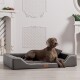 Ein grauer Weimaraner-Hund, der auf einem stilvollen grauen Haustierbett mit einem plüschigen Innenraum entspannt, in einem hellen, eleganten Raum mit weißer Dekoration.
