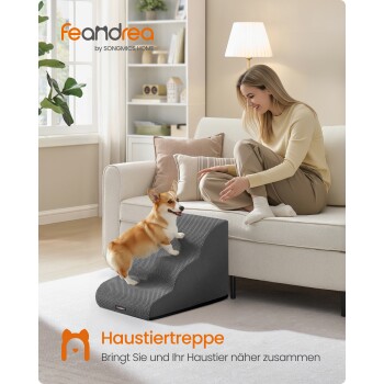 Corgi klettert eine graue Haustiertreppe zu einer auf dem Sofa sitzenden Frau hinauf; sichtbarer Text: 'feandrea by SONGMICS HOME' und 'Haustiertreppe'.