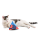 Eine entspannte weiß-graue Katze liegt neben einem bunten dreieckigen Katzenspielzeug mit der Silhouette einer Katze.