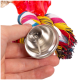 Eine Hand, die eine glänzende Metallglocke hält, die an einem bunten Haustierspielzeug aus geflochtenem Stoff und Kunststoff befestigt ist.