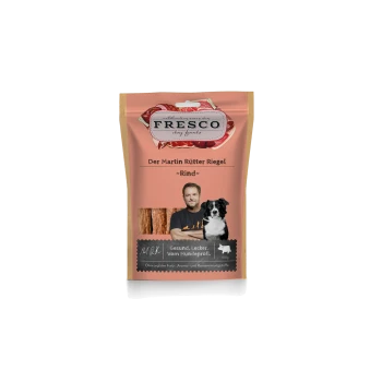 Fresco Hundefutterverpackung mit Rindfleisch-Leckerlis, zeigt einen Mann und einen schwarz-weißen Hund, beschriftet mit „Der Martin Rütter Riegel“.